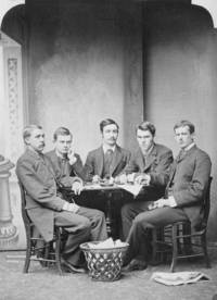 Five students sit together around a table