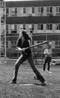 Student swings a bat during a softball game