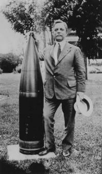 Dayton C. Miller standing next to a cannon shell