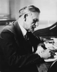 Albert A. Michelson sitting at a desk writing