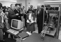 Yoh Han Pao, Don Schuele, Mary Boyle, and John Glenn look at computer equipment
